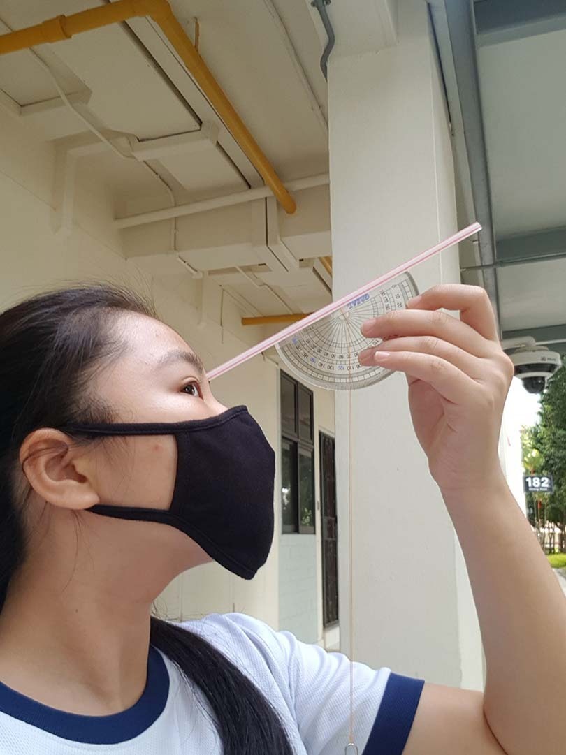 A Sec 2 student using a clinometer and applying trigonometric ratios to find the height of a building.jpg